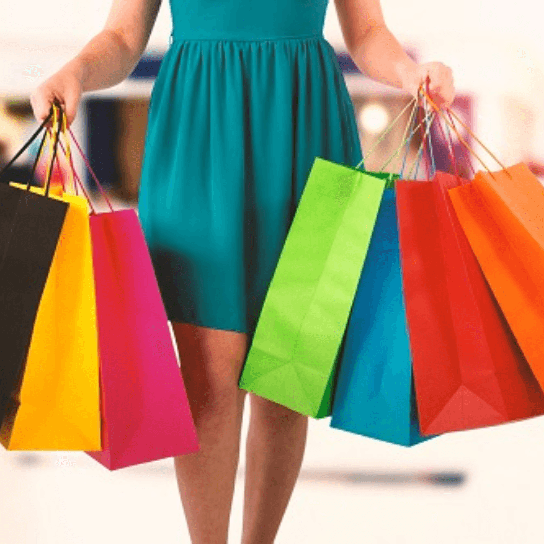 A shopper in a teal dress holding multiple colorful shopping bags, representing successful retail strategies